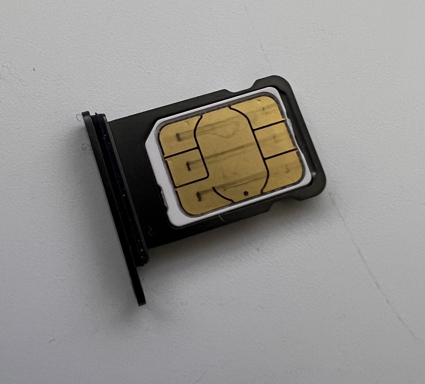 Old physical SIM card in a phone tray.